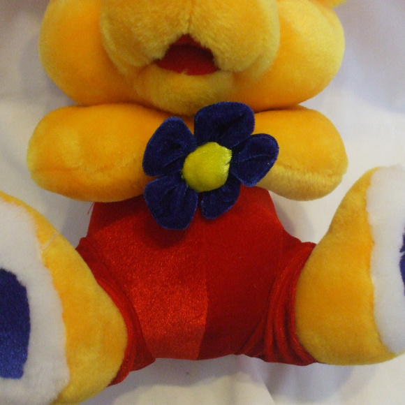 Yellow Teddy Bear With Red Pants Holding Flower - Picture 3 of 4